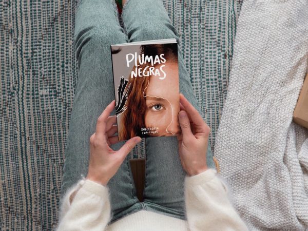 Manos agarrando el libro "Plumas negras" | Dolcerossa, Judit C. Miquel